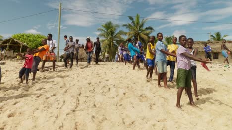 Boys-and-men-pull-fishing-net-out-of-sea-to-beach-in-Ghana,-frontal
