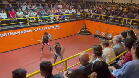 POV-SHOT-Many-foreigners-are-watching-the-sword-fight-and-two-men-are-fighting-in-the-arena