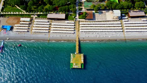 Aerial-4K-drone-wide-top-down-video-of-a-wooden-pier-near-hotel-resort-in-the-city-of-Kiriş---Kemer