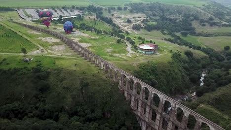 Drone-shot-and-tour-of-the-historical-site-"Arcos-del-Sitio"-during-the-assembly-of-hot-air-balloons-in-Tepotzotlán,-State-of-Mexico