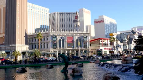 Bright-daylight-view-of-the-Las-Vegas-Strip-featuring-the-Venetian-and-Harrah's-hotels,-with-clear-blue-skies-and-a-lively-atmosphere