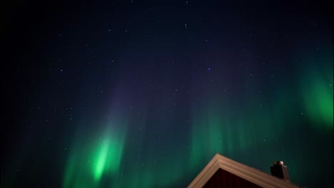 Fenómeno-Celestial-Conocido-Como-Aurora-Boreal,-Paleta-De-Colores-Verdes-En-La-Típica-Casa-Escandinava-Noruega-Y-Sueca