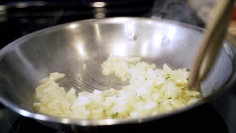 Volteando-Cebollas-En-Una-Sartén-Con-Aceite-De-Oliva-Preparando-Ingredientes-Para-Hacer-Vegano-Más-Allá-De-Albóndigas-Con-Espaguetis-Y-Salsa-De-Carne