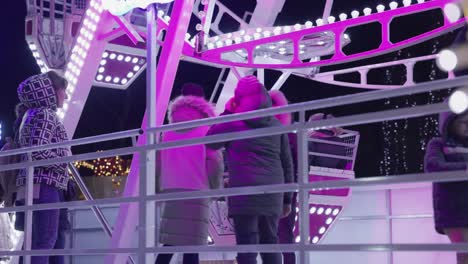 People-Waiting-In-Line-To-Ride-Ferris-Wheel-At-Night