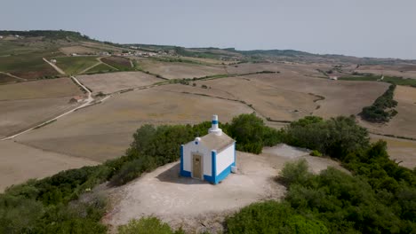 Aerial-180º-close-shot-of-ancient-chapel-of-Nossa-Senhora-do-Monte-in-Arruda-dos-Vinhos-in-Portugal
