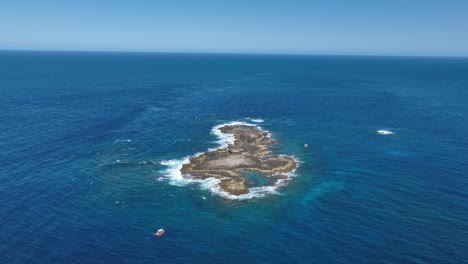 Aerial-Drone-shot-orbiting-Stradbroke-Islands-Point-Look-Out-Manta-Bommie-Dive-Site,-a-small-island-off-the-coast-of-Stradbroke-Island