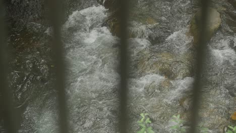 Water-rapids-seen-through-steel-railing