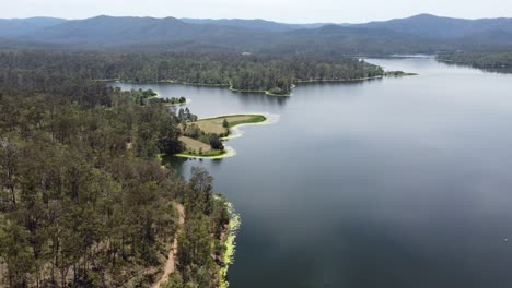 Drone-flying-over-a-beautiful-lake-towards-a-green-peninsula