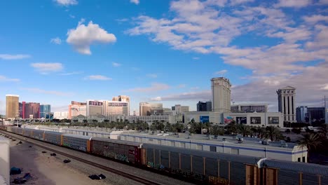 A-drone's-eye-view-captures-the-juxtaposition-of-bustling-Las-Vegas-luxury-with-the-grounded-reality-of-commerce,-depicted-by-the-train's-journey-past-the-iconic-skyline