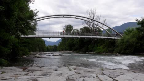 Cyclists-and-joggers-cross-a-bridge-over-the-river-Passirio---Passer,-Meran,-South-Tyrol,-Italy