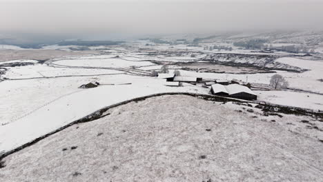 Establishing-Drone-Shot-of-Yorkshire-Dales-Farm-on-Snowy-Morning-UK