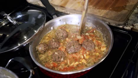 Aerial-shot-of-meatballs-cooking-in-a-steel-pan-Preparing-ingredients-to-make-vegan-beyond-meatballs-with-spaghetti-and-meat-sauce