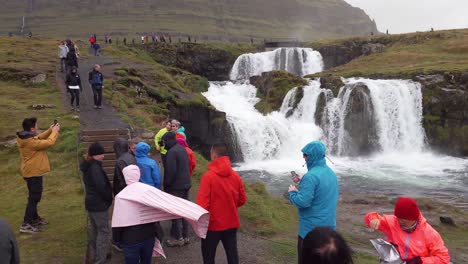 Group-of-tourists-in-the-windy-Iceland-nature-at-the-famous-Kirkjufellsfoss-waterfall