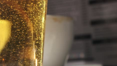 Macro-View-of-Beer-Bubbles-and-Foam-in-Glass-Against-Blurred-Backdrop