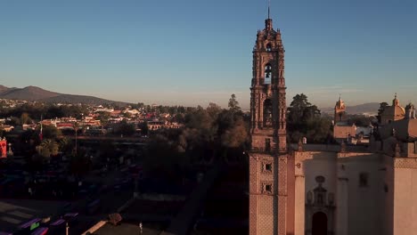 Close-up-drone-shot-at-dawn-of-the-bell-tower-of-the-San-Francisco-Javier-temple-in-Tepotzotlan,-State-of-Mexico,-Mexico