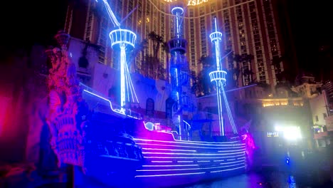 Tauchen-Sie-Ein-In-Das-Leuchtende-Neonlicht-Der-Legendären-Schiffsausstellung-Von-Treasure-Island-Und-Fangen-Sie-Die-Strahlenden-Blauen-Und-Violetten-Lichter-Ein,-Die-Die-Nacht-Verwandeln,-Und-Schaffen-Sie-Eine-Visuelle-Symphonie-Vor-Der-Skyline-Von-Vegas
