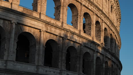 Sunrise-shadows-falling-across-roman-Colosseum-Italian-stone-amphitheatre-ruin-window-arches