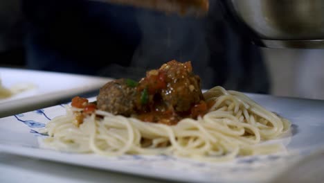 Adding-sauce-to-meatballs-plating-vegan-meatballs-Preparing-ingredients-to-make-vegan-beyond-meatballs-with-spaghetti-and-meat-sauce