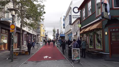 People-walking-in-the-city-shopping-street-in-Reykjavik,-Iceland