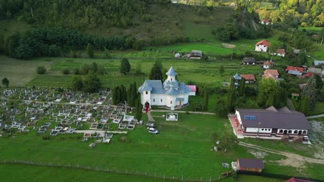Panoramic-Aerial-View-Of-An-Ancient-Church-And-Cemetery-In-Palanca,-Bacau-County,-Western-Moldavia,-Romania