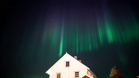 Colorful-northern-light-over-a-large-residential-house-in-Scandinavia,-Lofoten,-Norway