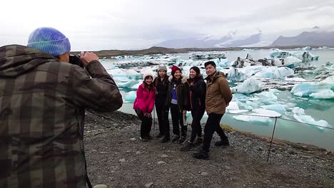 Group-of-friends-posing-for-a-picture-at-the-Jökulsárlón-Glacier-Lagoon-in-Iceland---Slow-motion