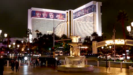Night-view-of-The-Mirage-in-Las-Vegas-featuring-the-Beatles'-'LOVE'-by-Cirque-du-Soleil,-with-a-fountain-in-the-foreground