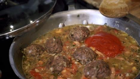 Adding-organic-tomato-sauce-into-pan-of-meatballs-Preparing-ingredients-to-make-vegan-beyond-meatballs-with-spaghetti-and-meat-sauce