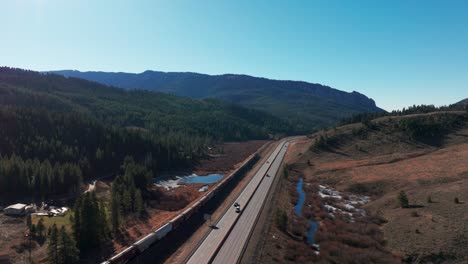 Drone-flyover-of-a-BNSF-Railway-train-with-mountains-in-the-background
