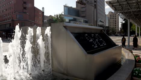 Outdoor-fountain-clock-at-JR-Kanazawa-Station-East-entrance-with-surrounding-buildings