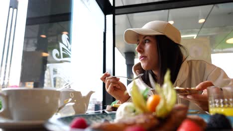 Low-angle-of-Caucasian-woman-chew,-swallow-restaurant-food-while-enjoying-view