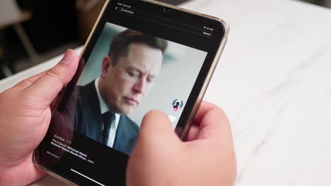 Man-using-tablet-watching-TIKTOK-application-for-Elon-Musk