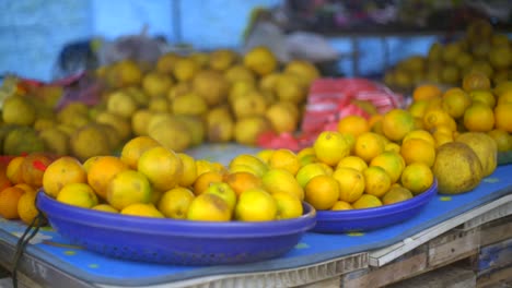 Trays-of-orange-citrus-fruit-placed-on-table,-filmed-as-close-up-handheld-slow-motion-shot