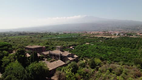 Beautiful-Drone-Shot-of-Castello-degli-Schiavi-and-Mount-Etna-in-the-Background-in-Sicily,-Italy