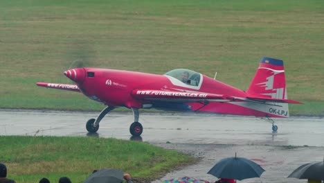 Red-Extra-330SC-aerobatic-monoplane-with-pilot-maneuvering-on-airstrip