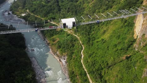 Aerial-orbit-shot-showing-bungee-jumping-spot-of-gigantic-bridge-with-freefall-in-nepal