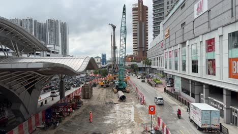 Street-scene-with-moving-traffic,-ongoing-construction-site-outside-Johor-Bahru-Sentral-Station-l-and-JB-City-Square,-a-shopping-mall-in-Johor,-Malaysia