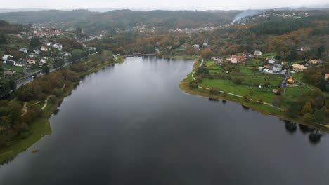 Beautiful-aerial-drone-shot-of-the-landscape-of-the-Cachamuiña-reservoir-on-a-cloudy-day-surrounded-by-trees