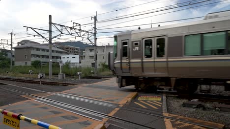 Tren-Local-Pasando-Por-El-Paso-A-Nivel-En-Arashiyama,-Kyoto