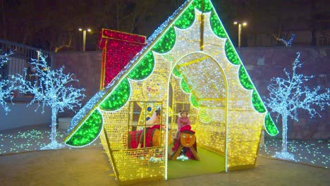 Weihnachtshaus-Aus-Lichtern-Mit-Darin-Spielenden-Kindern-In-Barcelona,-Spanien