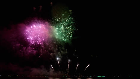 Eine-Platzende-Mischung-Aus-Bunten,-Hellen-Lichtern-Erfüllte-Den-Nachthimmel-Bei-Einem-Feuerwerksfestival-An-Einem-Strand-In-Südostasien