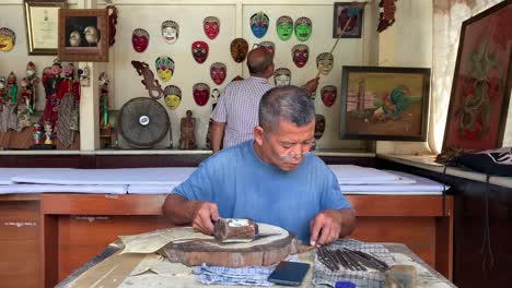 Yogyakarta,-Indonesia---Dec-16,-2023-:-Indonesian-old-man-making-carving-wayang-shadow-puppet