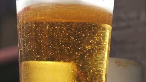 Glistening-Beer-Glass-in-Slow-Motion,-Sunny-Day-at-Bar