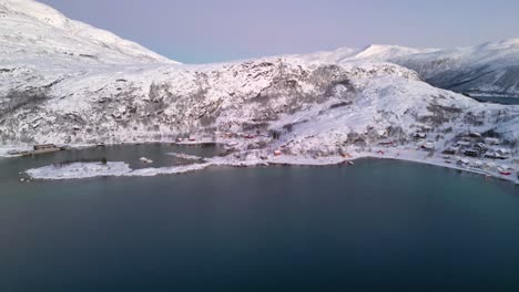Discovering-majestic-Norwegian-fjords-and-Ersfjordvegen-village-with-snowy-mountains-and-blue-sea
