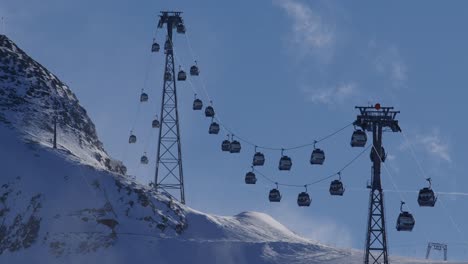 Gondola-lift-bringing-people-up-the-mountain-for-skiing-and-snowboarding-with-a-blizzard