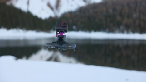 Drone-with-creative-Insta360-Ace-Pro-action-camera-mounted-on-top-and-snowy-mountain-landscape-and-lake-in-background