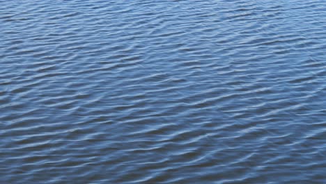 Abstract-water-surface-with-small-waves-and-sky-reflection