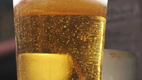 Vaso-De-Cerveza-Radiante-En-Cámara-Lenta-En-Una-Soleada-Barra-De-Bar