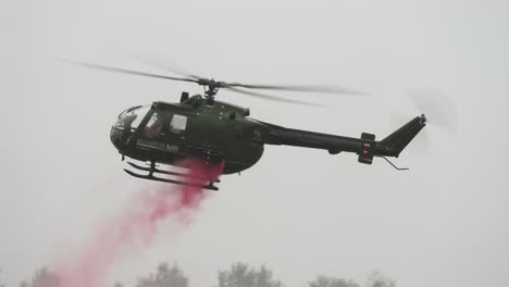 Twin-engine-MBB-Bo105-helicopter-fly-backwards-with-red-smoke-during-airshow