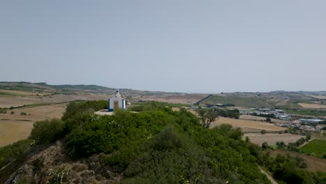 Aerial-drone-shot-at-distance-of-ancient-chapel-of-Nossa-Senhora-do-Monte-in-Arruda-dos-Vinhos-in-Portugal